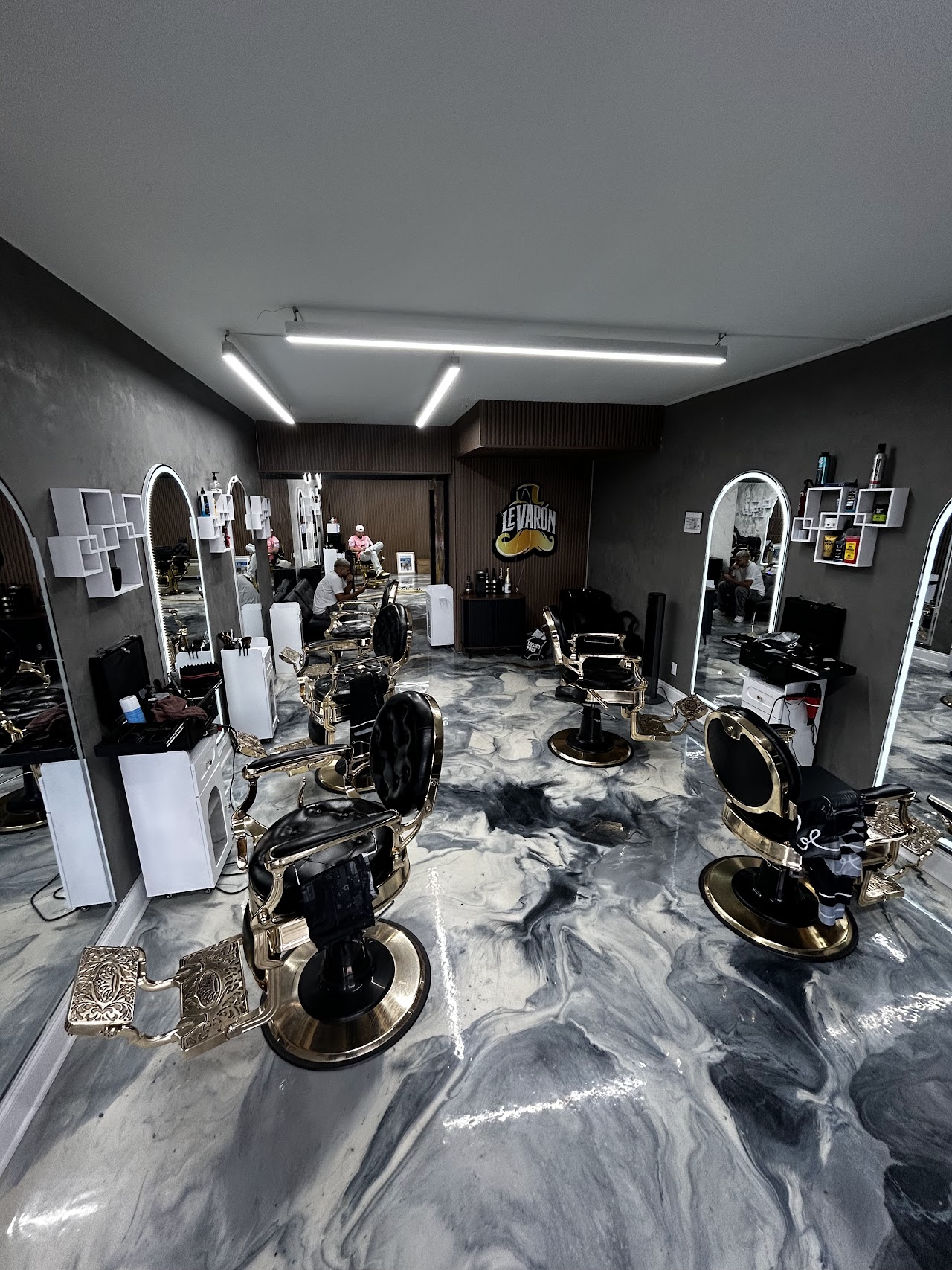 Le Varon Barbershop interior with gold barber chairs and marble floors
