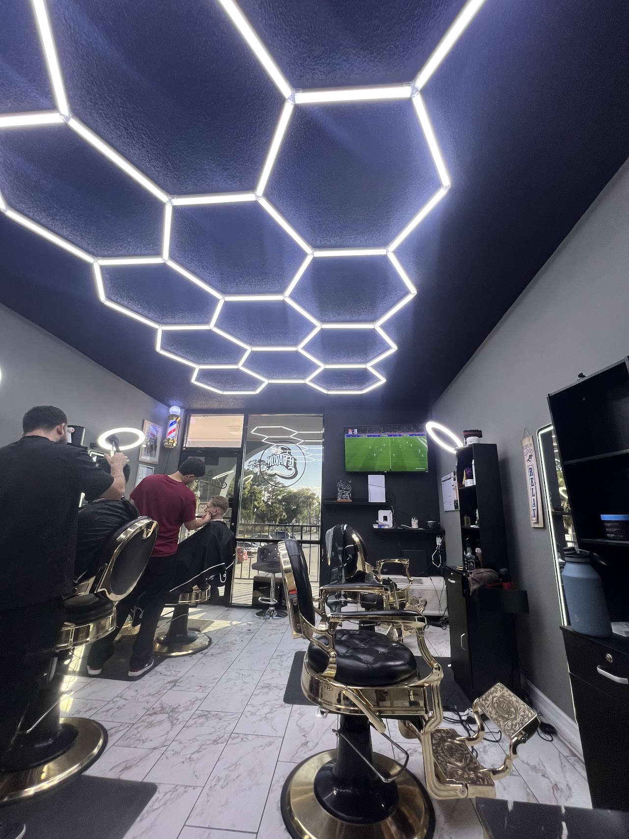 Le Varon Barbershop honeycomb LED ceiling and gold barber chairs